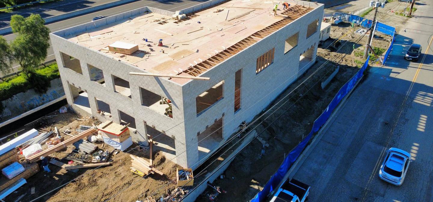 PJ Empire crew sheathing the roof deck of the 555 Light Industrial shell, seen from above